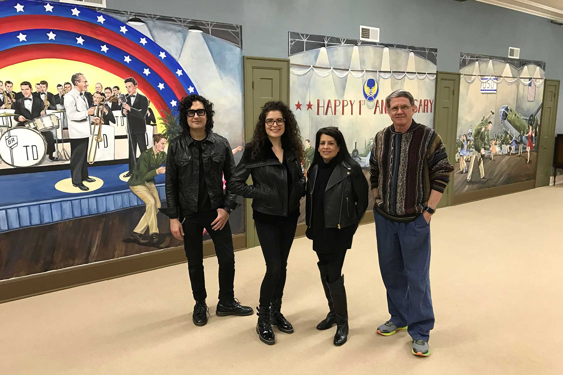 a photo of Scott and Melissa Tucker and two others posing in front of their Murals