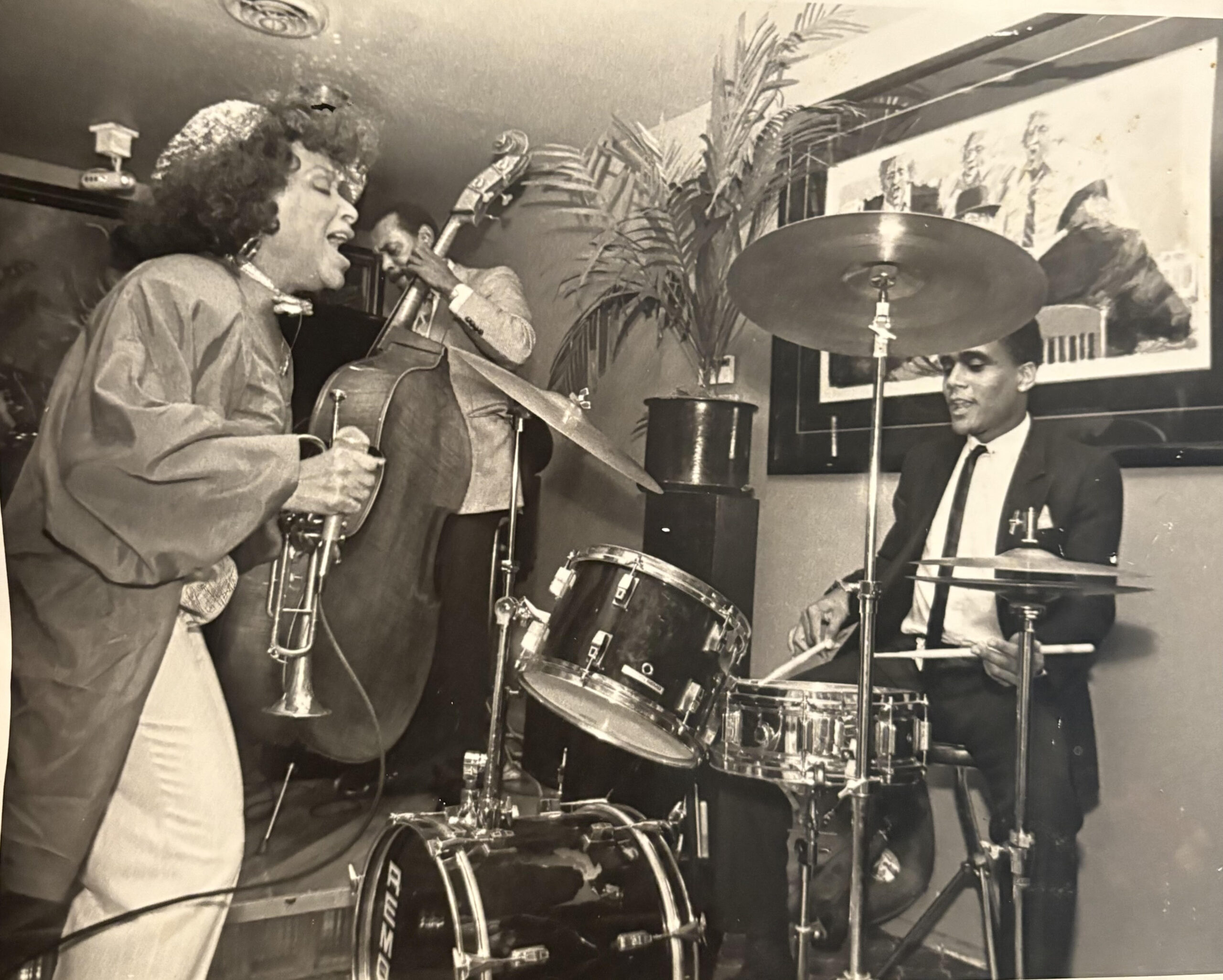 Photo of a mural with early big band orchestra with people dancing in front of it.